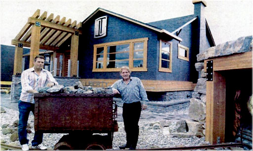Len Lindstrom (right), president and CEO of Liberty International Mineral Corporation., stands with his son and vice-president, Michael Lindstrom, with an 1890s era mining ore car in front of their new offices on Lawrence Avenue.